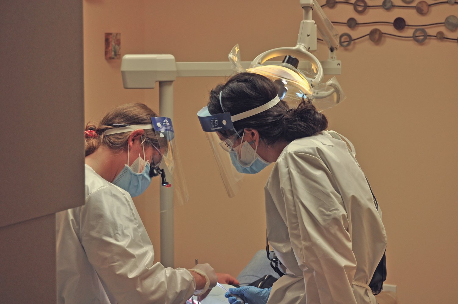 Dental students Nicole Quint, left, and Leah Bullock work on a patient at the Dr. Mary Ludwig Montgomery County Free Clinic on Saturday. Weekly urgent dental care clinics are scheduled at the clinic.
